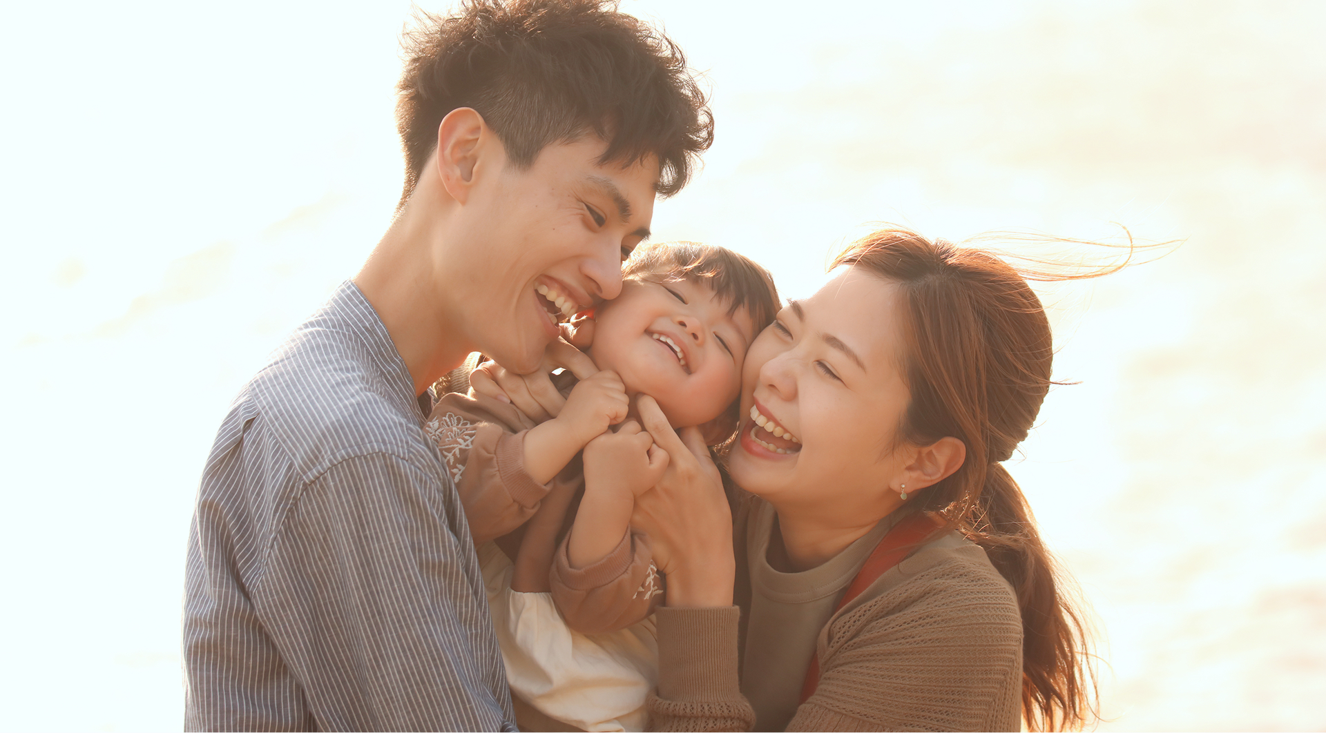 若い夫婦が間に子供を抱っこしている写真