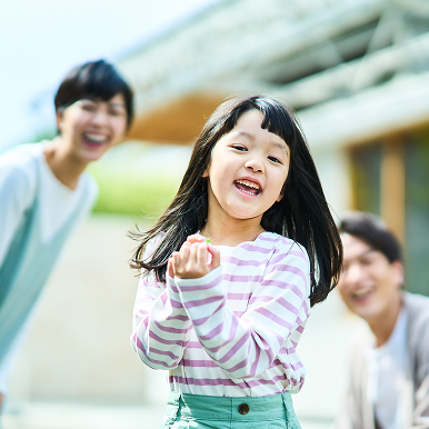 笑顔の女の子と見守る夫婦の写真