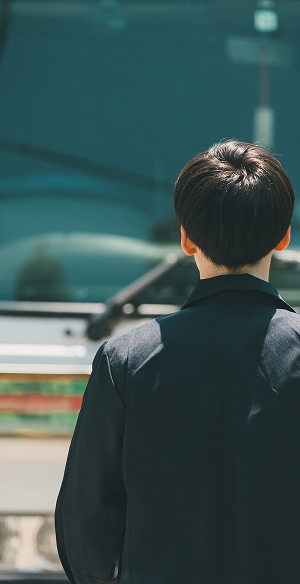 トラックを見ている男性の後ろ姿の写真